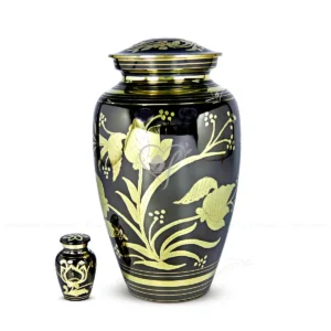 Bella 10-inch premium brass cremation urn in a black steel oxidized finish featuring hand-engraved polished brass floral accents and a secure threaded lid.