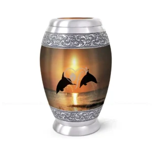 Golden Leap 10-inch aluminum cremation urn featuring a High-Gloss Graphic Wrap of dolphins leaping at sunset with hand-engraved silver floral bands.