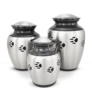 Midnight Paws pet cremation urns in various sizes, featuring a painted slate neck and lid with a brushed aluminum body and black hand-engraved paw prints.
