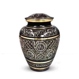 Black Radiance 9-inch solid brass cremation urn in an Elite shape, featuring a high-gloss black finish and intricate hand-engraved gold-tone floral and geometric patterns with a secure threaded lid.