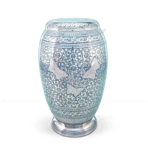 Celestial Flutter 10-inch Monarch shaped solid brass cremation urn featuring Shiny Nickel plating, Sky Blue hand-engraved floral patterns, and embossed silver-tone butterflies.