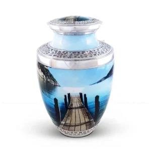 Serene Pathway 10-inch aluminum cremation urn featuring a High Gloss Lakeside Graphic Wrap with a wooden dock and hand-engraved floral silver-tone bands.