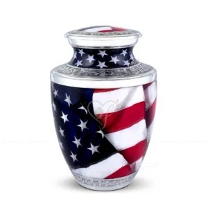 Liberty Wave 10-inch Treisty shape aluminum cremation urn featuring a vibrant American Flag waving design and hand-engraved silver-tone floral bands.